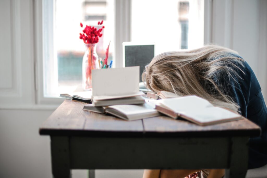 Træt kvinde læner sig op af bordet pga. mangel på god søvn